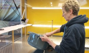 Mitarbeiterin im Foodtruck „Pommes Goldgelb“ bereitet Zutaten in einer Schüssel vor.