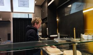 Mitarbeiterin im Foodtruck „Pommes Goldgelb“ in Verden bereitet frische Pommes in umweltfreundlichen Schalen vor.